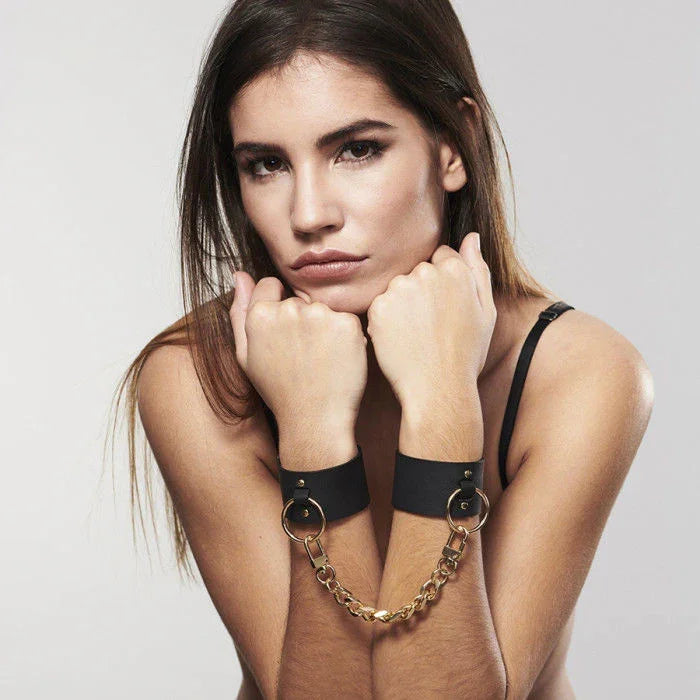 Conjunto de esposas y brazaletes negros de cuero con cadena y anillas metálicas