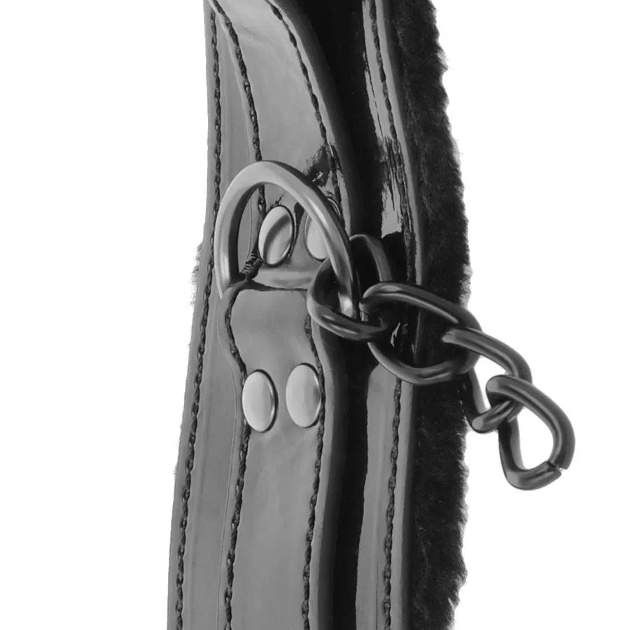 Tobillera de cuero negro brillante con cadena metálica y anilla central