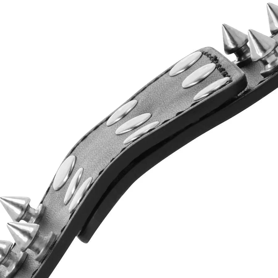 Brazalete negro con pinchos metálicos y hebilla redonda, con piel texturizada